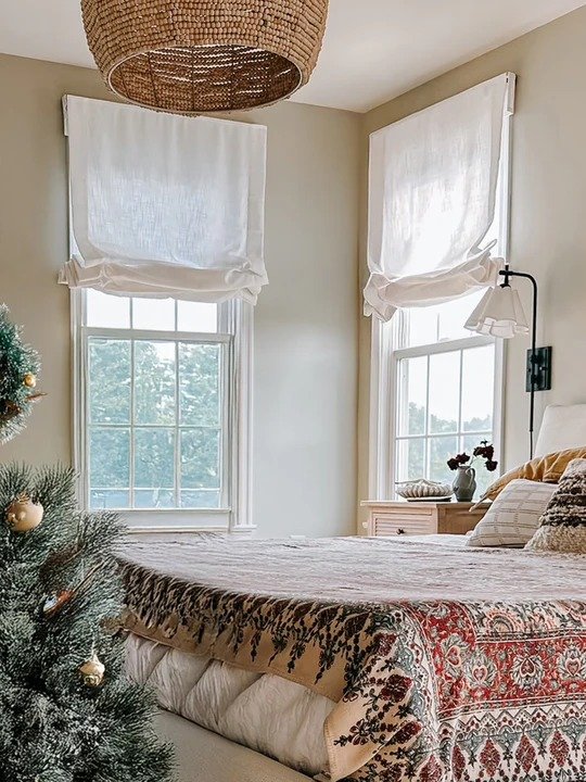 Cafe curtains covering the lower half of a window, allowing soft natural light from the top, styled as outdoor curtains on a cozy patio with neutral tones and a breezy fabric flow